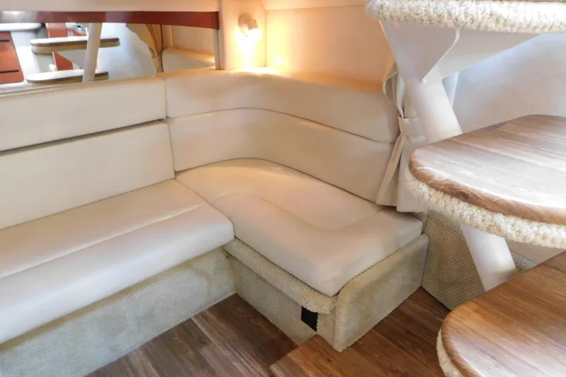 Slide: The Image of Interior of 2005 Sea Ray 320 Sundancer with beige seating and wooden accents. - 54
