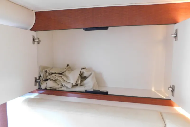 Slide: The Image of Open cabinet with folded fabric inside, Sea Ray 320 Sundancer 2005 interior detail. - 56