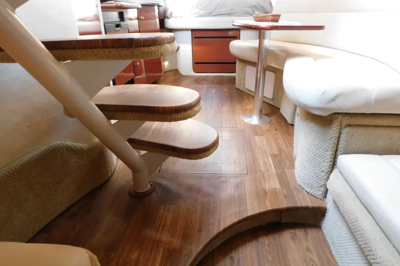 Slide: The Image of Interior of 2005 Sea Ray 320 Sundancer with wooden flooring and cozy seating area. - 57