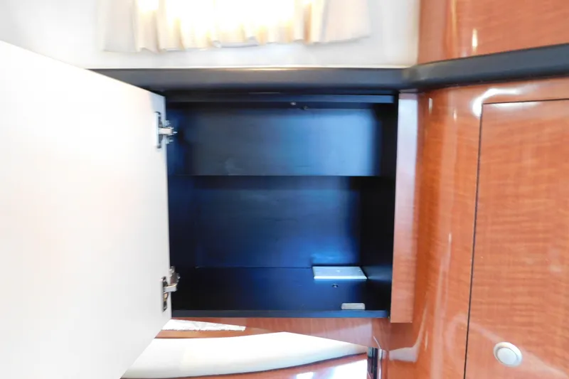 Slide: The Image of Open cabinet inside 2005 Sea Ray 320 Sundancer yacht, featuring wooden finish. - 66