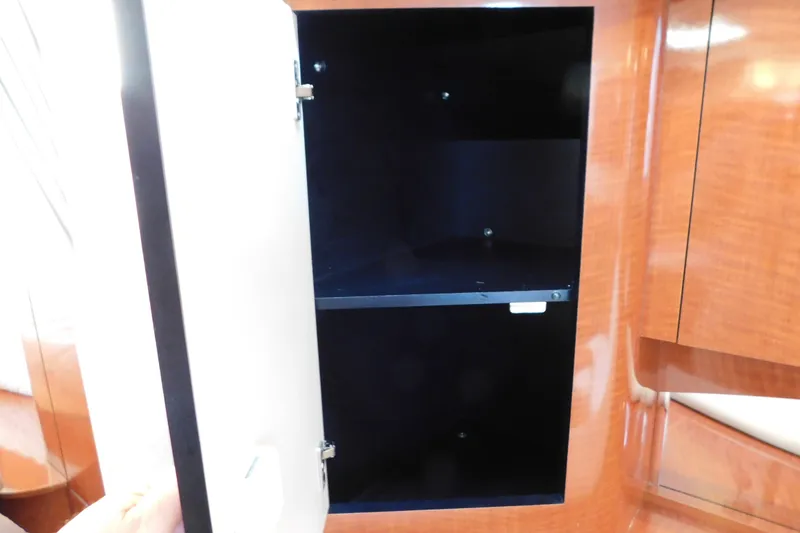 Slide: The Image of Open cabinet inside 2005 Sea Ray 320 Sundancer boat, featuring wooden interior design. - 68