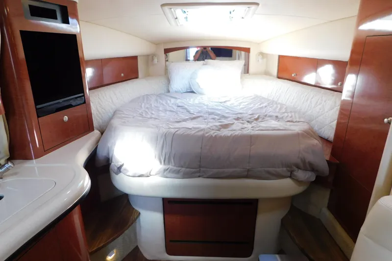 Slide: The Image of Luxurious cabin interior of 2005 Sea Ray 320 Sundancer with cozy bed and wooden cabinetry. - 69