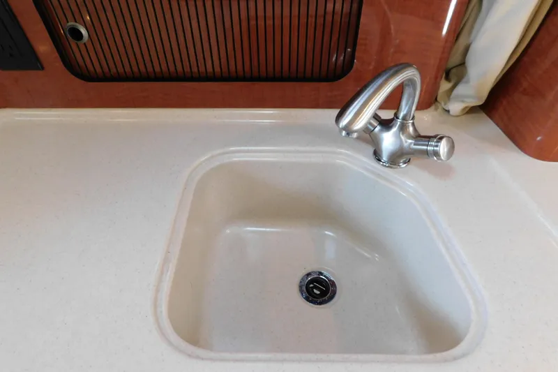 Slide: The Image of Kitchen sink and faucet in 2005 Sea Ray 320 Sundancer boat interior. - 83
