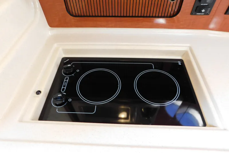 Slide: The Image of 2005 Sea Ray 320 Sundancer stovetop with dual burners in cabin kitchen. - 84