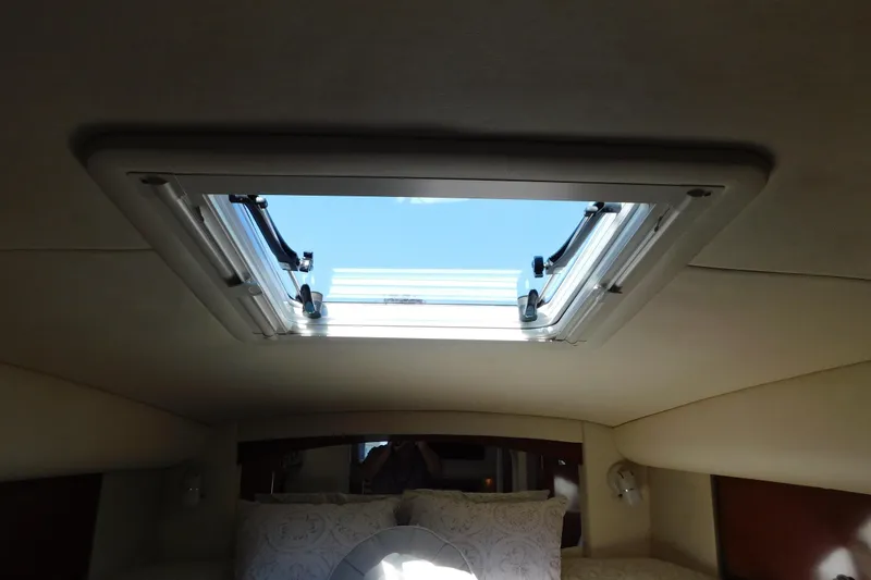 Slide: The Image of 2005 Sea Ray 320 Sundancer cabin interior with open skylight, showcasing natural light. - 93