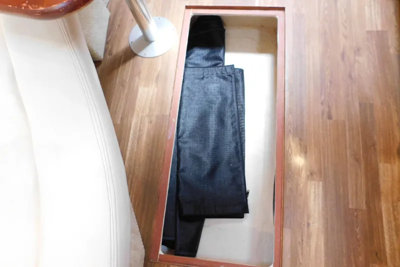 Slide: The Image of Storage compartment on 2005 Sea Ray 320 Sundancer boat with folded black jeans inside. - 95