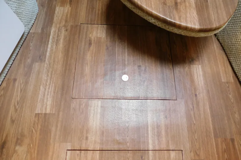 Slide: The Image of Wooden floor of 2005 Sea Ray 320 Sundancer boat interior, featuring a hatch. - 96