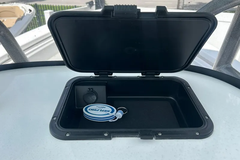 Slide: The Image of Open storage compartment on 2026 Sea Pro 222 Center Console boat with key fob inside. - 16