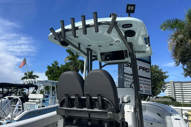 Slide: The Image of 2026 Sea Pro 222 Center Console boat with rod holders and T-top, under a clear blue sky. - 3