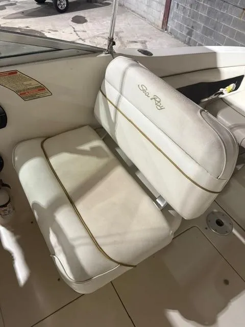 Slide: The Image of 1999 Sea Ray 215 Express Cruiser boat seat with white upholstery and logo. - 10