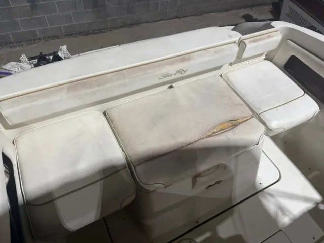 Slide: The Image of 1999 Sea Ray 215 Express Cruiser interior seating with visible wear and tear. - 12