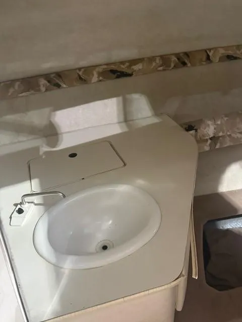 Slide: The Image of 1999 Sea Ray 215 Express Cruiser interior sink area with countertop and faucet. - 15