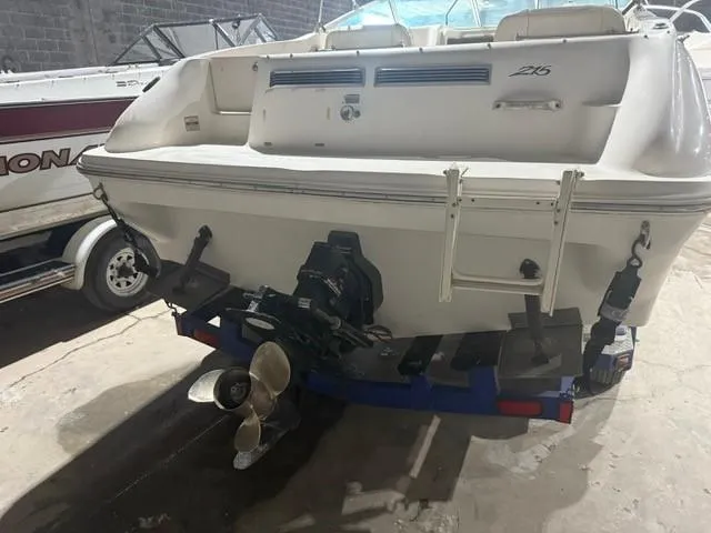 Slide: The Image of 1999 Sea Ray 215 Express Cruiser boat on trailer, rear view in storage. - 7