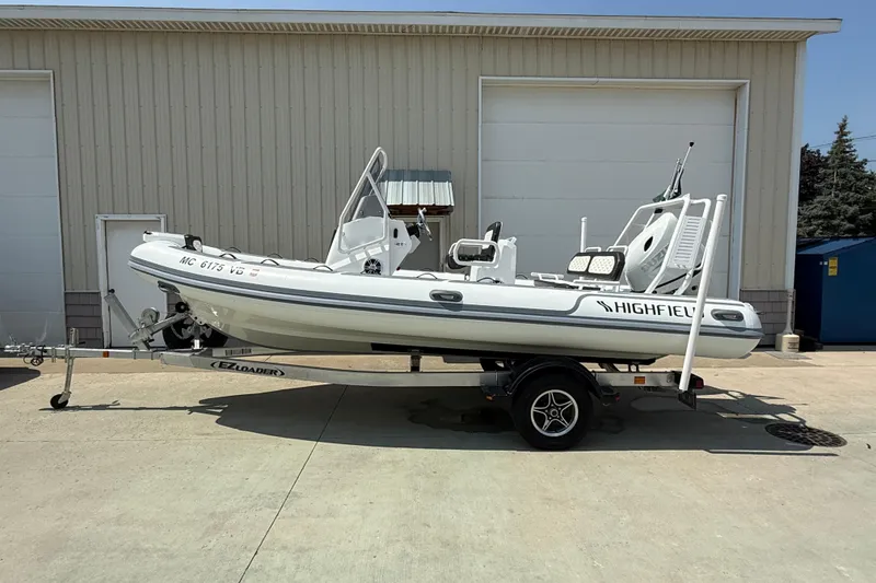 The Image of 2025 Highfield Sport 560 boat on trailer, parked outside a warehouse. - 1