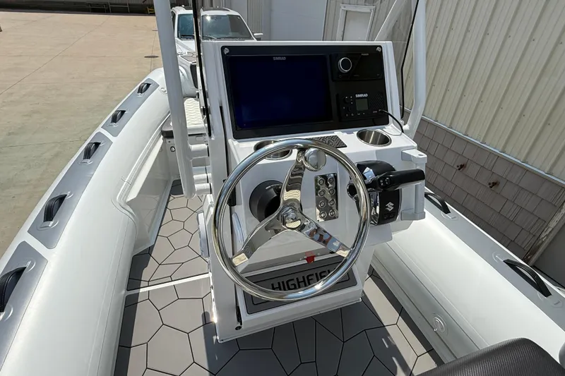 Slide: The Image of 2025 Highfield Sport 560 boat dashboard with steering wheel and navigation controls. - 14