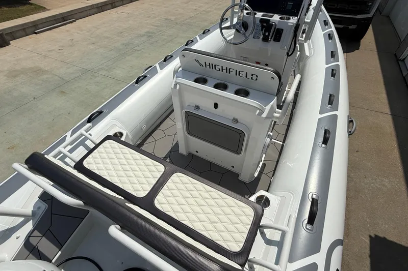 Slide: The Image of 2025 Highfield Sport 560 boat interior with steering console and cushioned seating. - 18