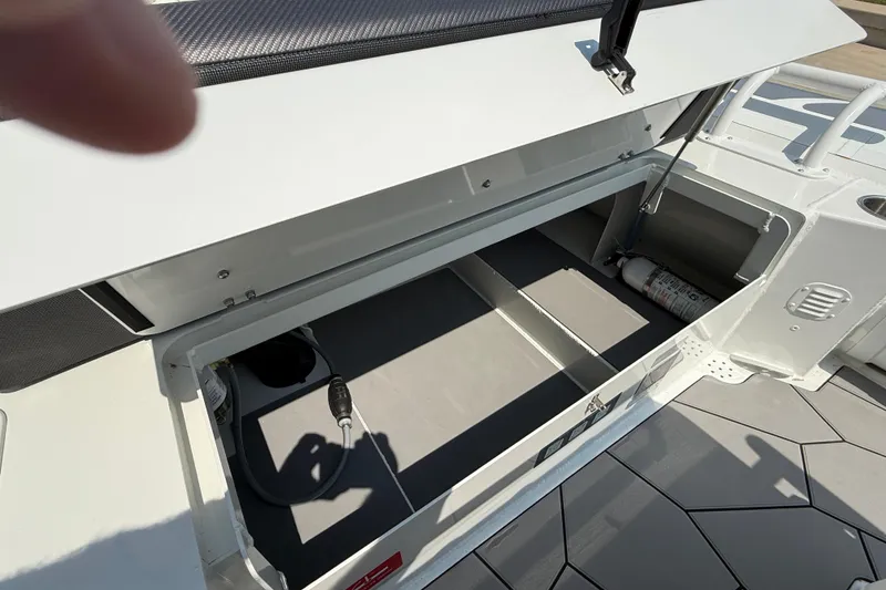 Slide: The Image of Open storage compartment on 2025 Highfield Sport 560 boat, featuring a fire extinguisher. - 21