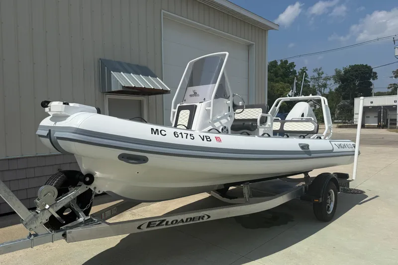 Slide: The Image of 2025 Highfield Sport 560 boat on trailer, parked outside a building. - 28