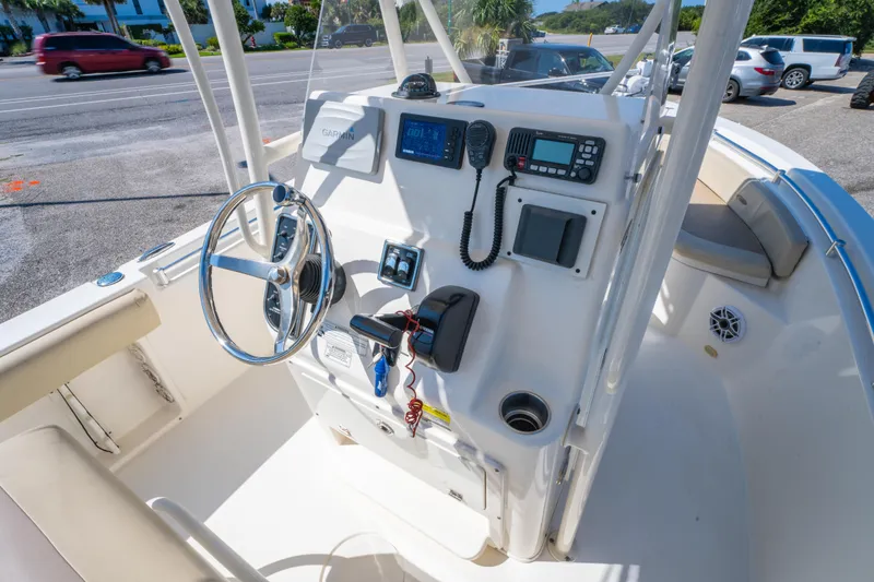 Slide: The Image of 2016 Cobia 201 Center Console boat dashboard with steering wheel and navigation equipment. - 11