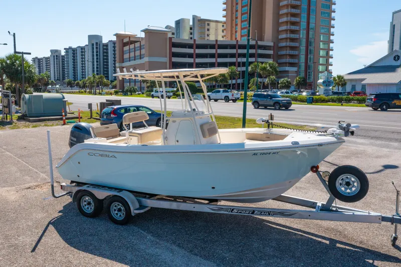 Slide: The Image of 2016 Cobia 201 Center Console boat on trailer, urban background with high-rise buildings. - 2