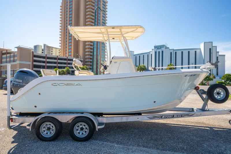 Slide: The Image of 2016 Cobia 201 Center Console boat on trailer, urban backdrop, sunny day. - 3