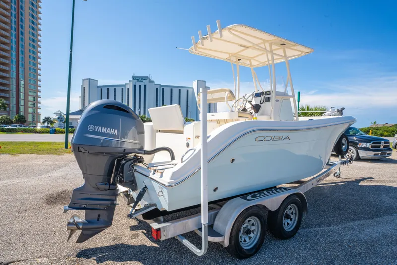 Slide: The Image of 2016 Cobia 201 Center Console boat with Yamaha engine on trailer, urban backdrop. - 5
