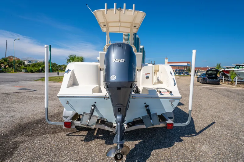 Slide: The Image of 2016 Cobia 201 Center Console boat with Yamaha 150 engine, parked on a sunny day. - 6
