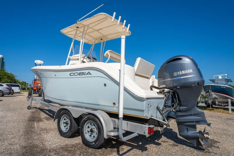 Slide: The Image of 2016 Cobia 201 Center Console boat with Yamaha engine on trailer, under clear blue sky. - 7