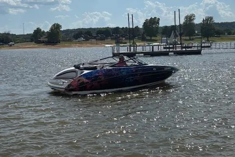 Slide: The Image of 2010 Yamaha Boats 212SS on a sunny lake with dock and trees in background. - 10