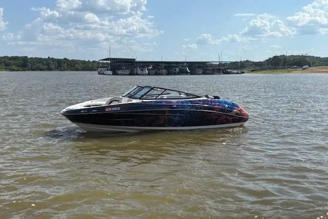 Slide: The Image of 2010 Yamaha Boats 212SS on a lake with marina in background. - 15