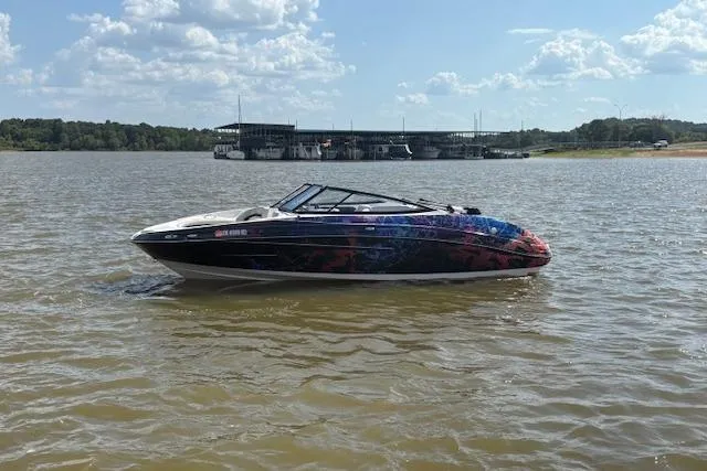 Slide: The Image of 2010 Yamaha Boats 212SS on a lake with scenic background and cloudy sky. - 16