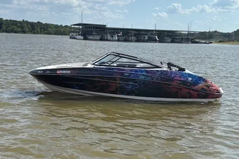 Slide: The Image of 2010 Yamaha Boats 212SS with colorful graphics on a lake. - 17