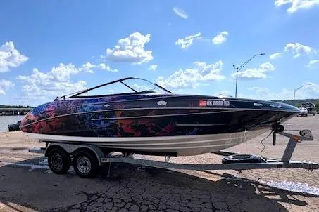 Slide: The Image of 2010 Yamaha Boats 212SS on trailer, vibrant design, parked under blue sky. - 19