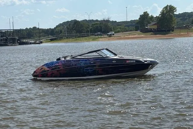 Slide: The Image of 2010 Yamaha Boats 212SS on a lake with colorful graphics, surrounded by scenic landscape. - 7