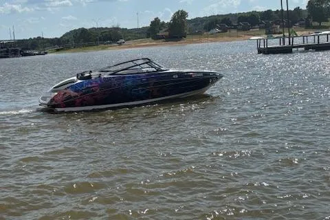 Slide: The Image of 2010 Yamaha Boats 212SS cruising on a sunny lake with scenic background. - 9