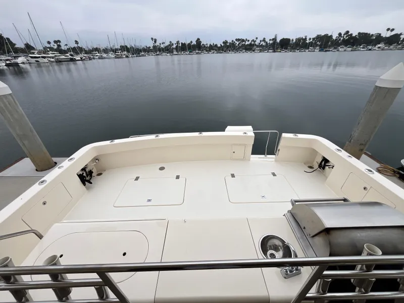 Slide: The Image of 1999 Mikelson Long-Range Luxury Sportfisher docked, featuring spacious deck and marina view. - 10