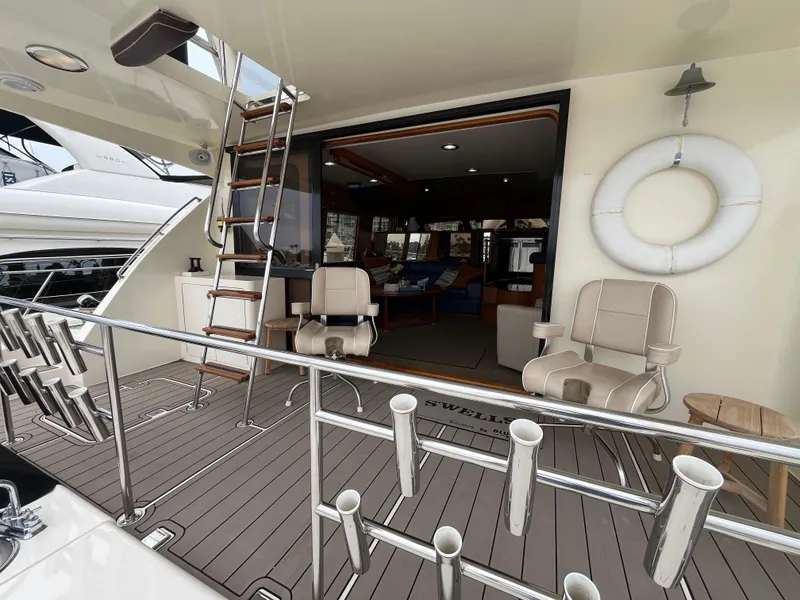 Slide: The Image of 1999 Mikelson Long-Range Luxury Sportfisher yacht deck with seating and ladder. - 16
