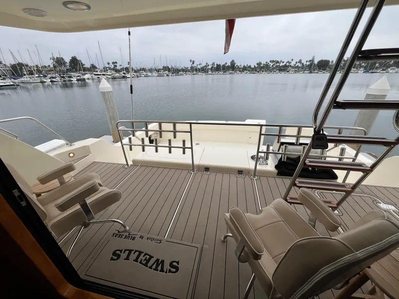 Slide: The Image of 1999 Mikelson Long-Range Luxury Sportfisher deck with chairs, overlooking marina. - 18