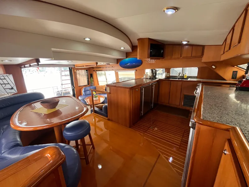 Slide: The Image of Luxurious interior of a 1999 Mikelson Long-Range Luxury Sportfisher yacht with elegant wood finishes. - 24