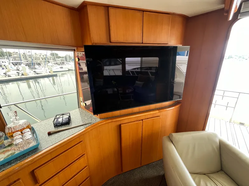 Slide: The Image of Interior of 1999 Mikelson Long-Range Luxury Sportfisher with TV, leather chair, and marina view. - 34