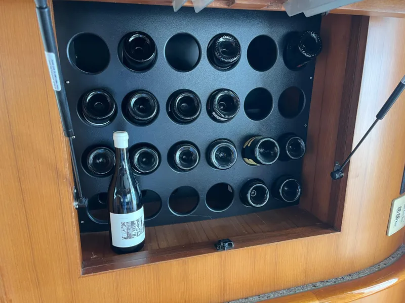 Slide: The Image of Wine rack on 1999 Mikelson Long-Range Luxury Sportfisher, featuring multiple bottles. - 36