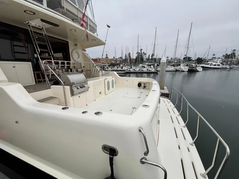 Slide: The Image of 1999 Mikelson Long-Range Luxury Sportfisher yacht docked at marina, featuring spacious deck. - 6