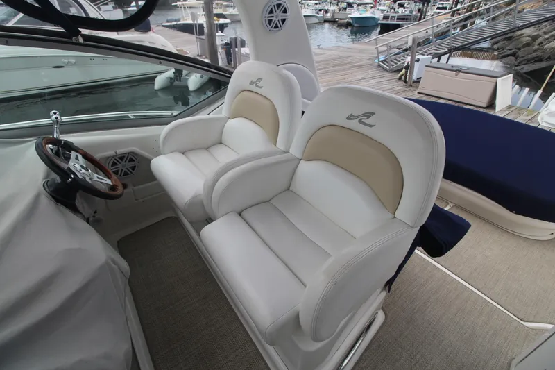 Slide: The Image of 2008 Sea Ray 340 Sundancer helm with dual white leather seats at marina. - 17