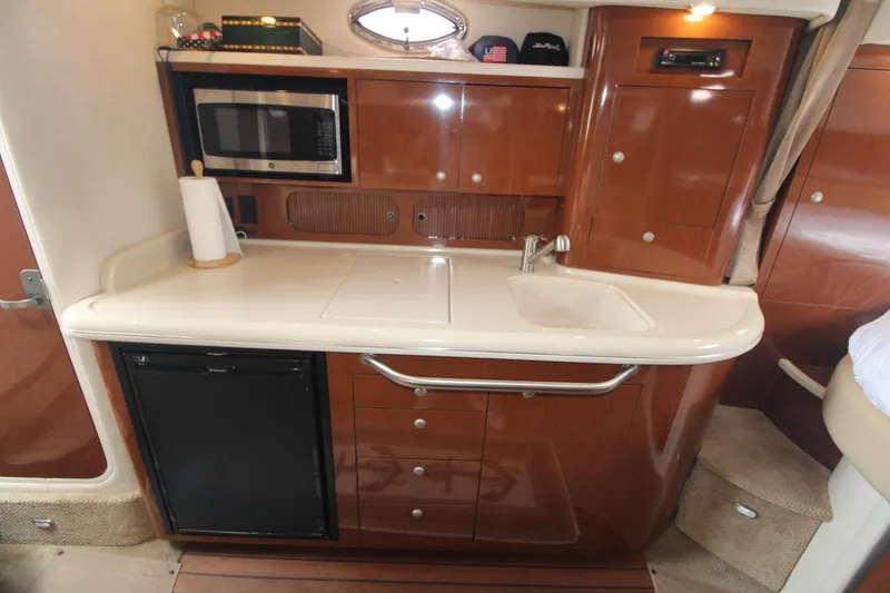 Slide: The Image of 2008 Sea Ray 340 Sundancer galley with microwave, sink, and storage cabinets. - 27