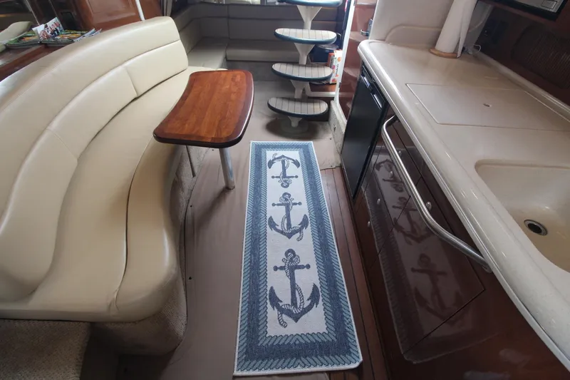 Slide: The Image of Interior of 2008 Sea Ray 340 Sundancer with beige seating and anchor-themed rug. - 31