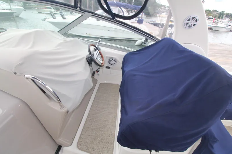 Slide: The Image of 2008 Sea Ray 340 Sundancer cockpit with covered seats and steering wheel. - 6