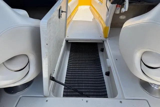 Slide: The Image of 2005 Crownline 210 LPX boat interior with open storage compartment and seating. - 11