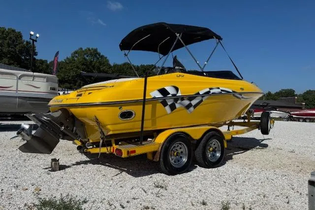 Slide: The Image of Yellow 2005 Crownline 210 LPX boat with checkered flag design on a trailer. - 3