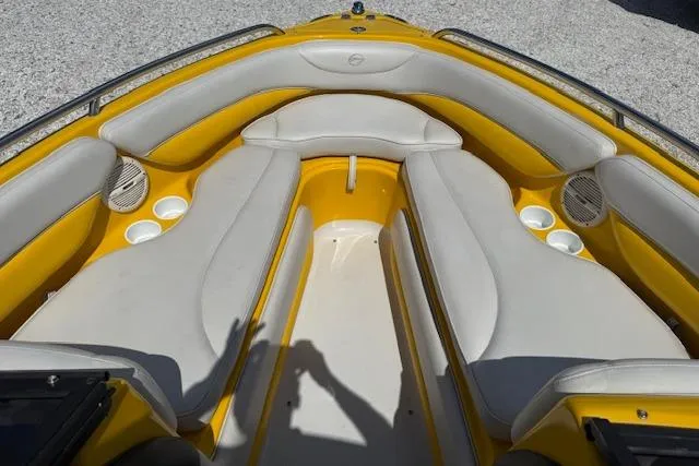Slide: The Image of 2005 Crownline 210 LPX boat interior with yellow and white seating, cup holders, and speakers. - 5