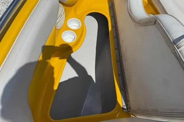 Slide: The Image of 2005 Crownline 210 LPX boat interior with yellow accents and cup holders. - 6